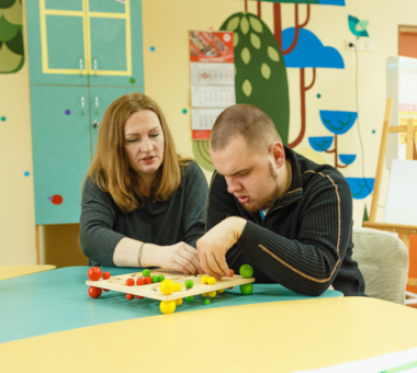 woman helping male patient do puzzles